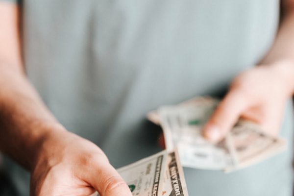 Free Crop man paying with American dollars Stock Photo