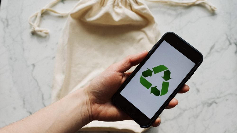 Free Faceless person showing recycle symbol on mobile phone screen Stock Photo