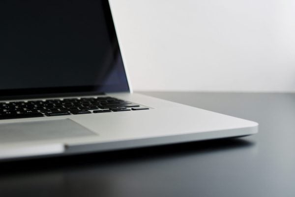 silver laptop computer on black table