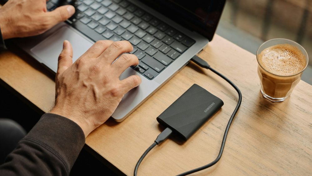 A man sitting at a table using a laptop computer