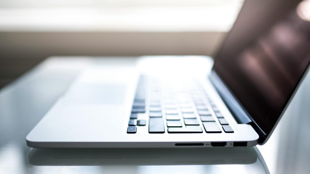 Free Elegant side view of a laptop on a glossy table with natural lighting indoors. Stock Photo